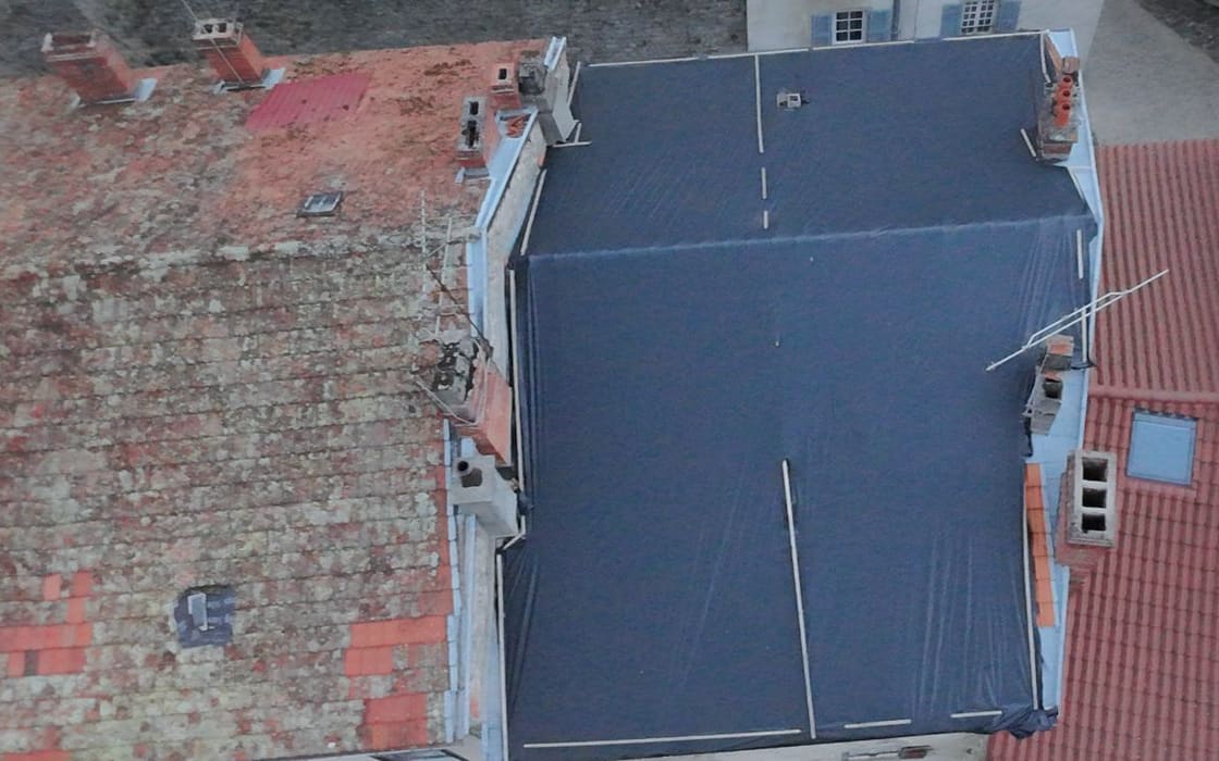 Immeuble de bourg entièrement bâché et latté après dépose de la couverture, vue du drone.