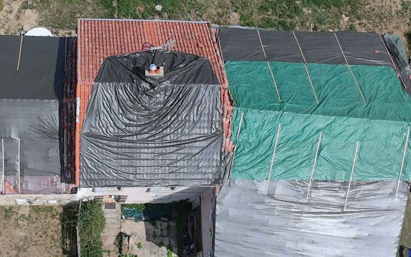 Toiture bâchée et lattée en travers pour une mise hors d’eau, vue du drone.