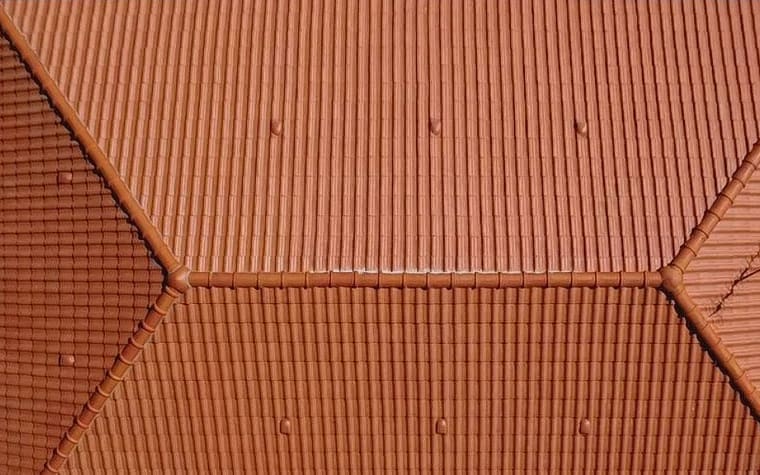 La même toiture à quatre pans vue du drone à l’aplomb, tuiles nettoyées et pose régulière.